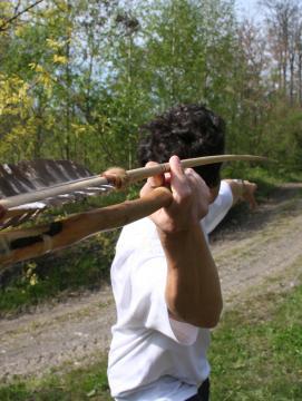 Photo couleur. Un compétiteur de tir préhistorique se prépare à lancer sa sagaie vers une cible.